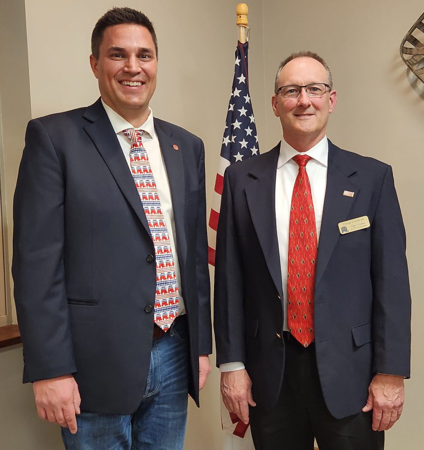 Two men in suits and ties standing next to each other.